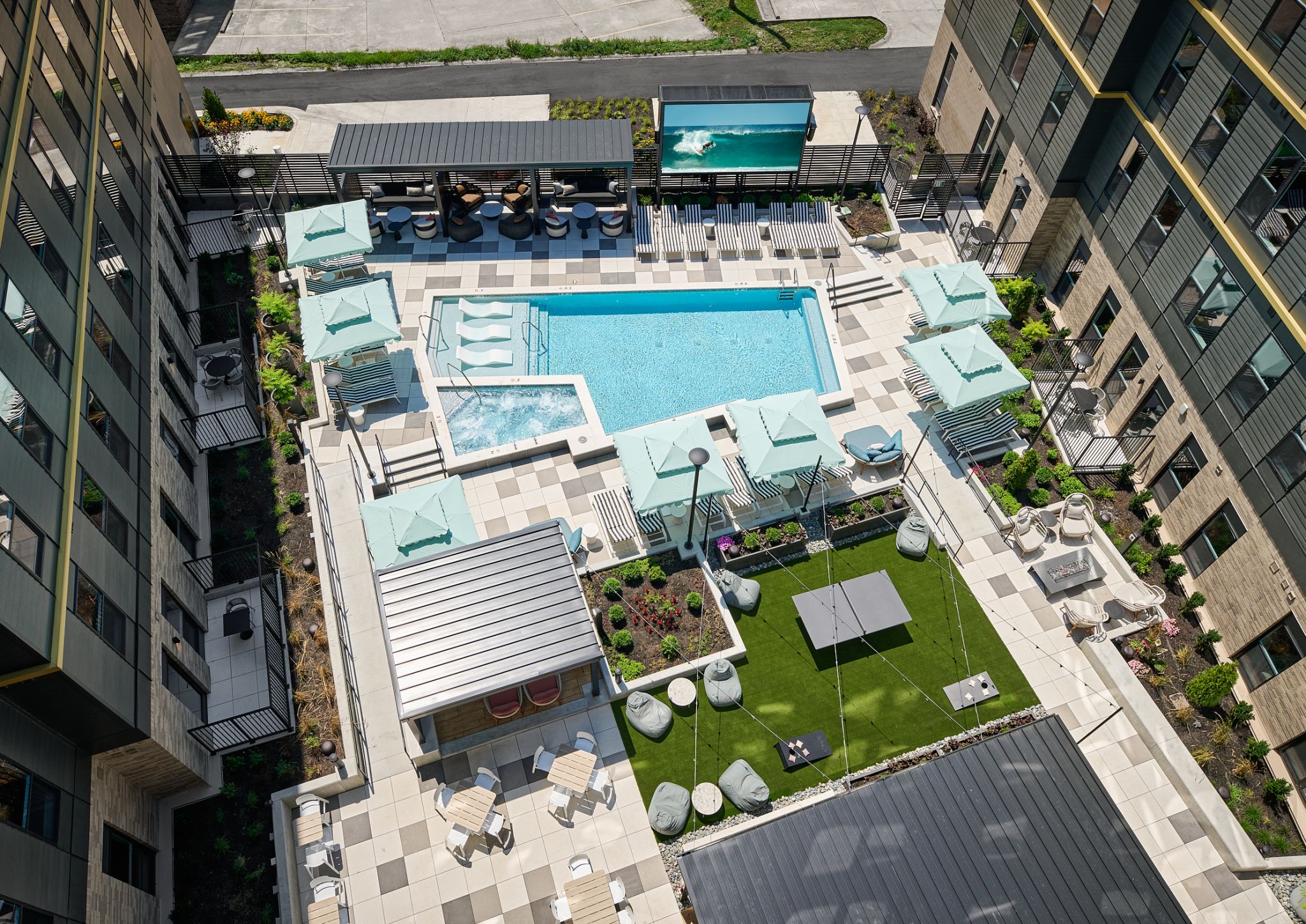 EVER West Lafayette: vista aérea del patio exterior con piscina y zona de descanso ajardinada rodeada de apartamentos.
